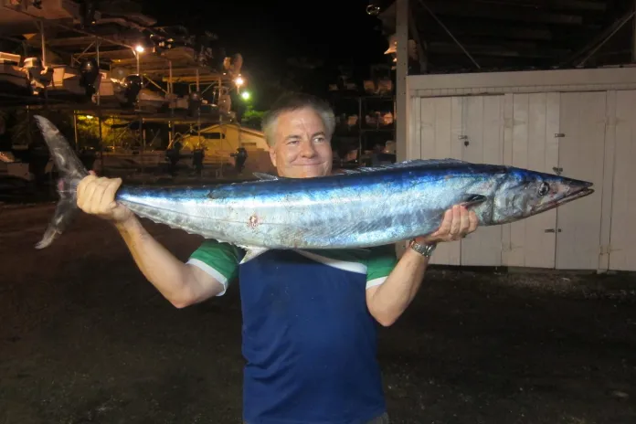 #Column: Try trolling at night - A young man holding a fish - Sardine