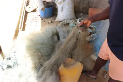Leon-Kisito-holding-oily-nets-Ebodje-Cameroon